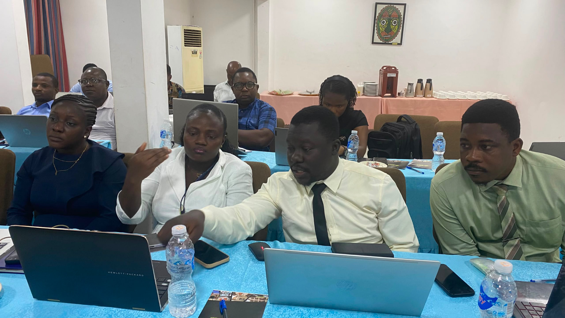 Participants collaborating around laptops during an applied learning exercise