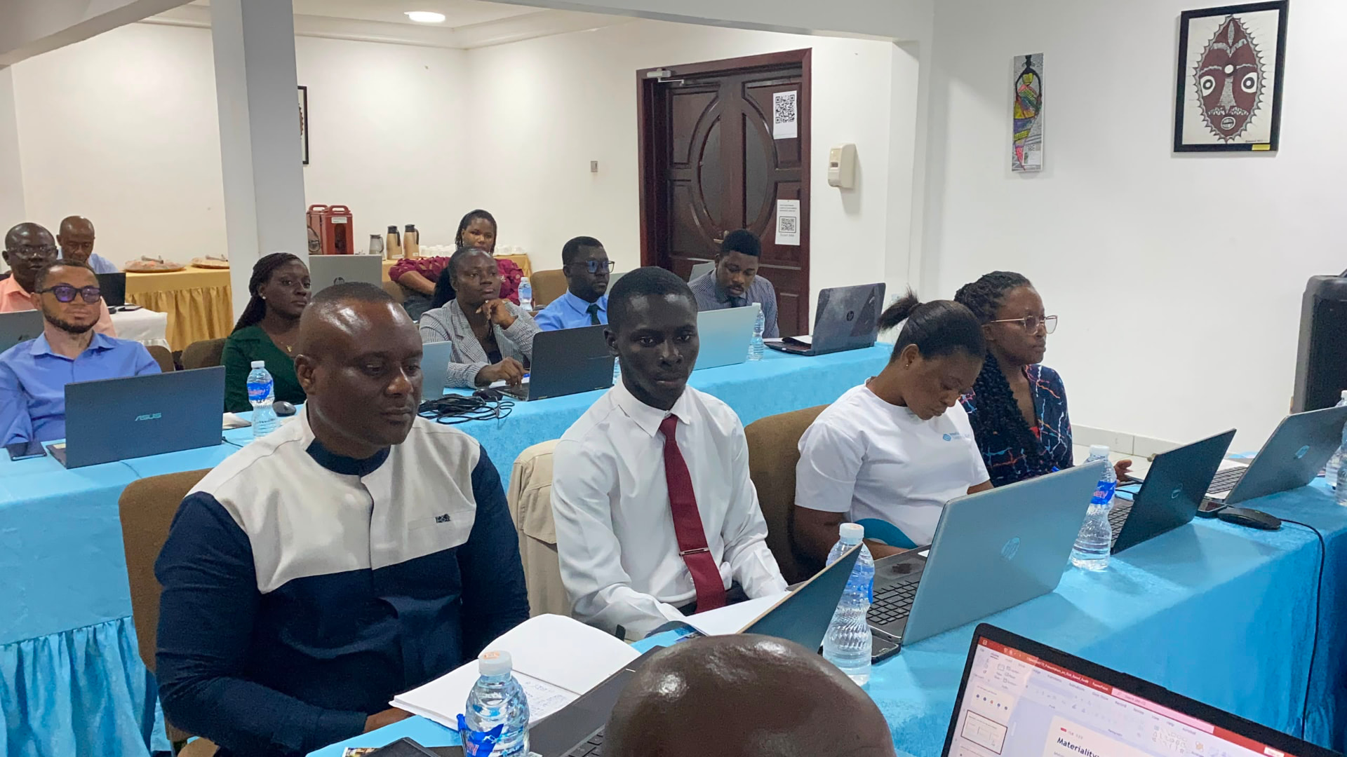 Professionals working through a practical classroom exercise on laptops
